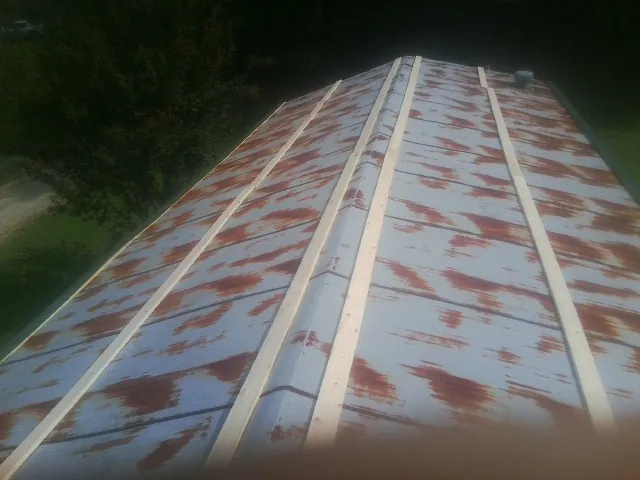 Rusted metal roof panels with new wood purlins before replacement — Storm Damage Roof Repair in Churchville by Roofing Brothers