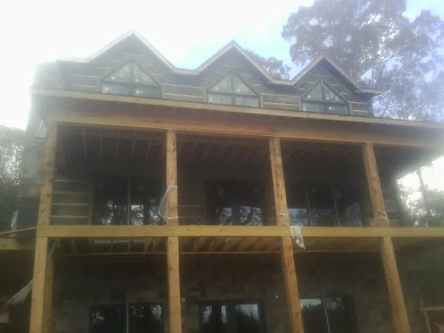 Dormers and porch framing on a large log home under construction in Churchville